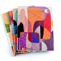 Quaderno notebooks stack by Jomike Tejido with Evening Skyline notebook on top